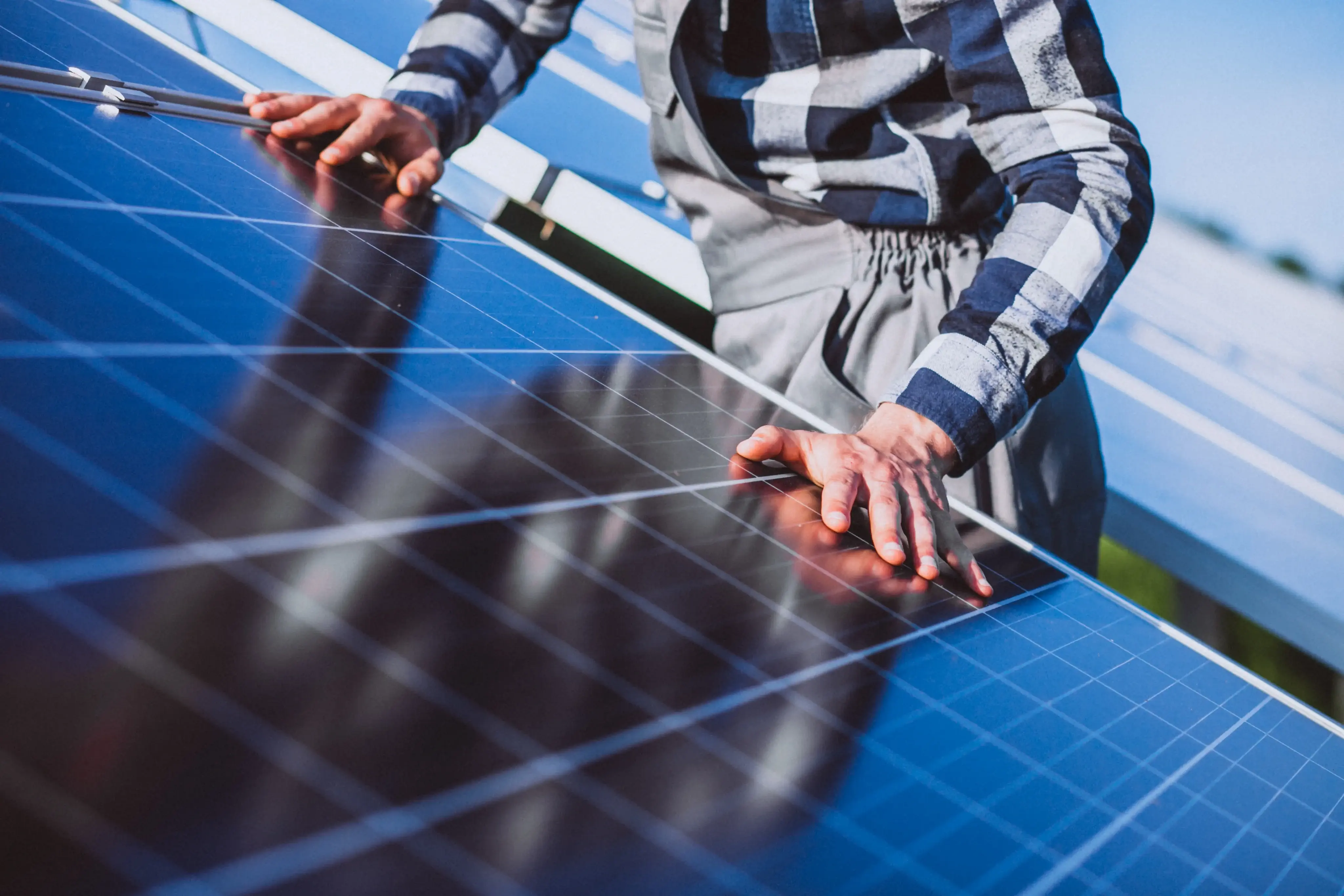 Image d'une personne touchant un panneau photovoltaïque